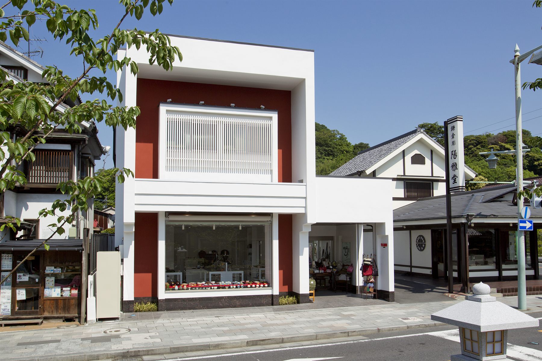 鶴岡八幡宮 三の鳥居前に建つ鎌倉やしろの外観。白い箱に弁柄色の一枚壁。